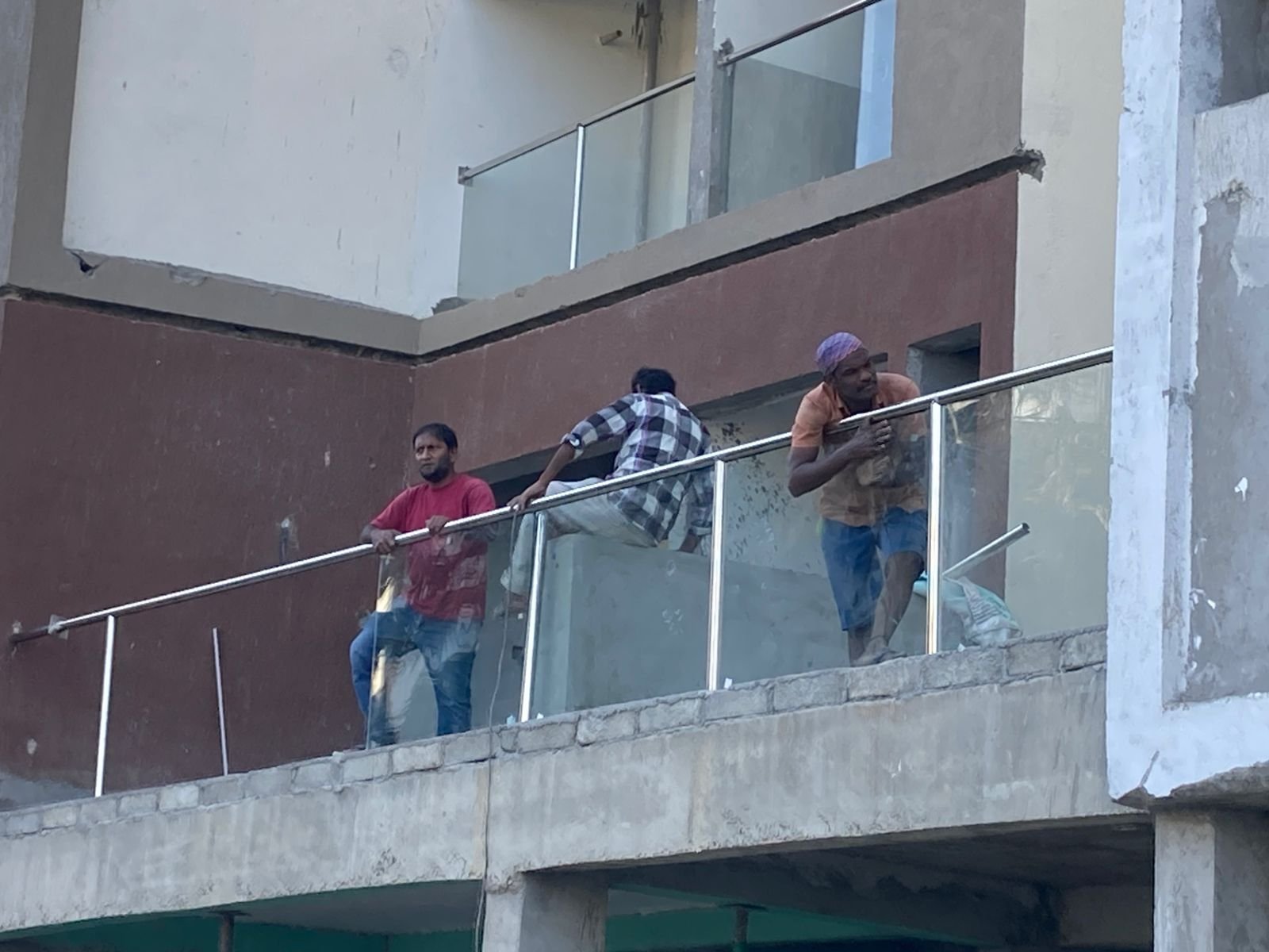 Glass balcony railing being installed on a residential building