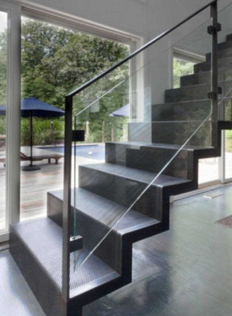 Stainless steel and glass handrail along an indoor staircase